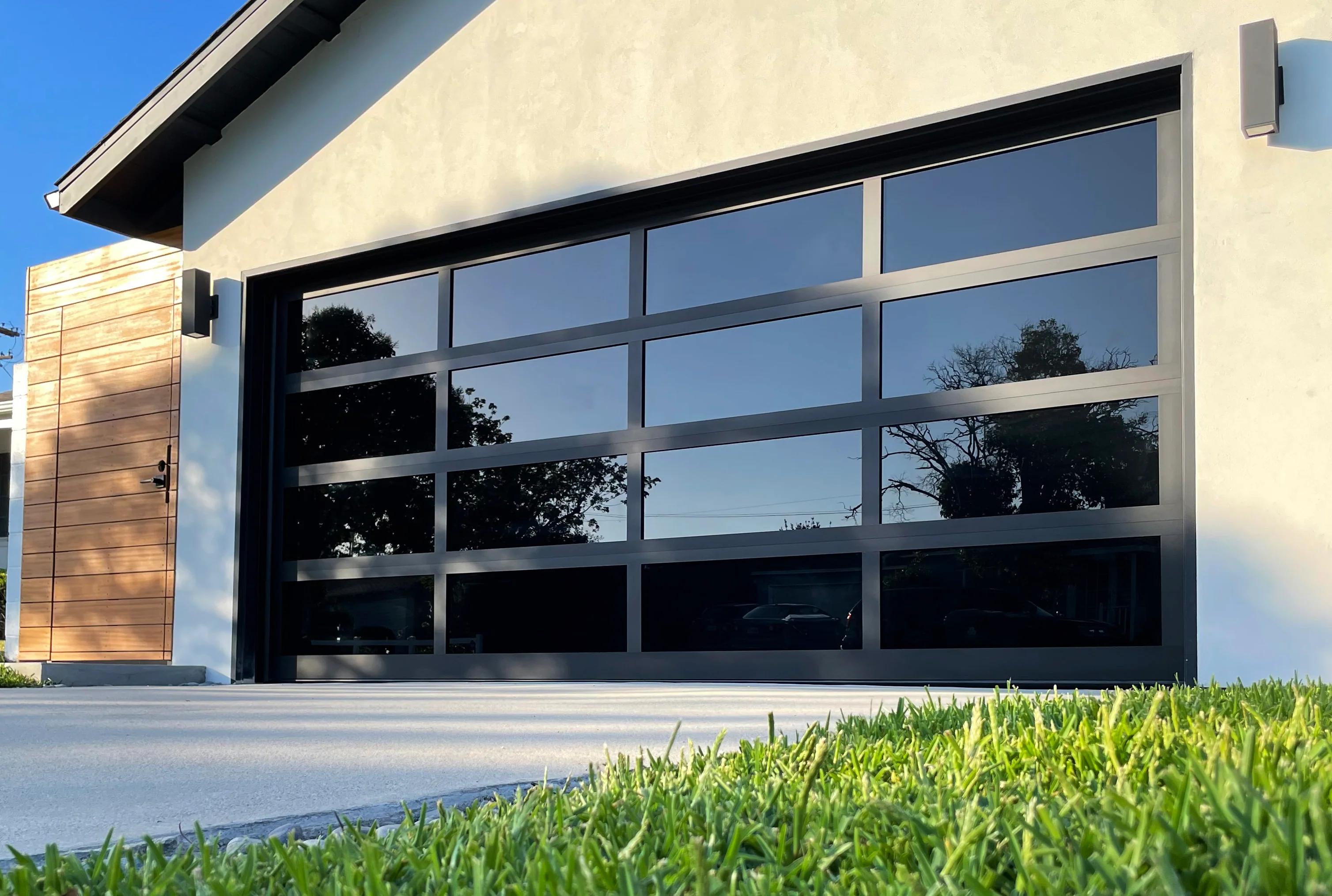 Frameless black-framed full-view glass garage door on a modern home